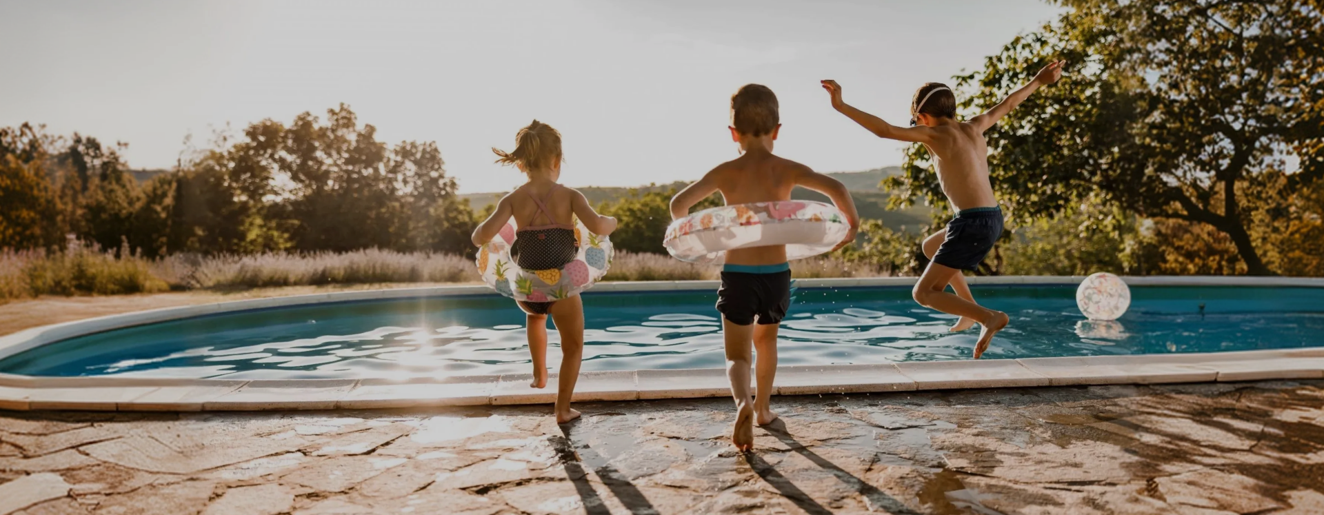 Children running into a heated backyard pool