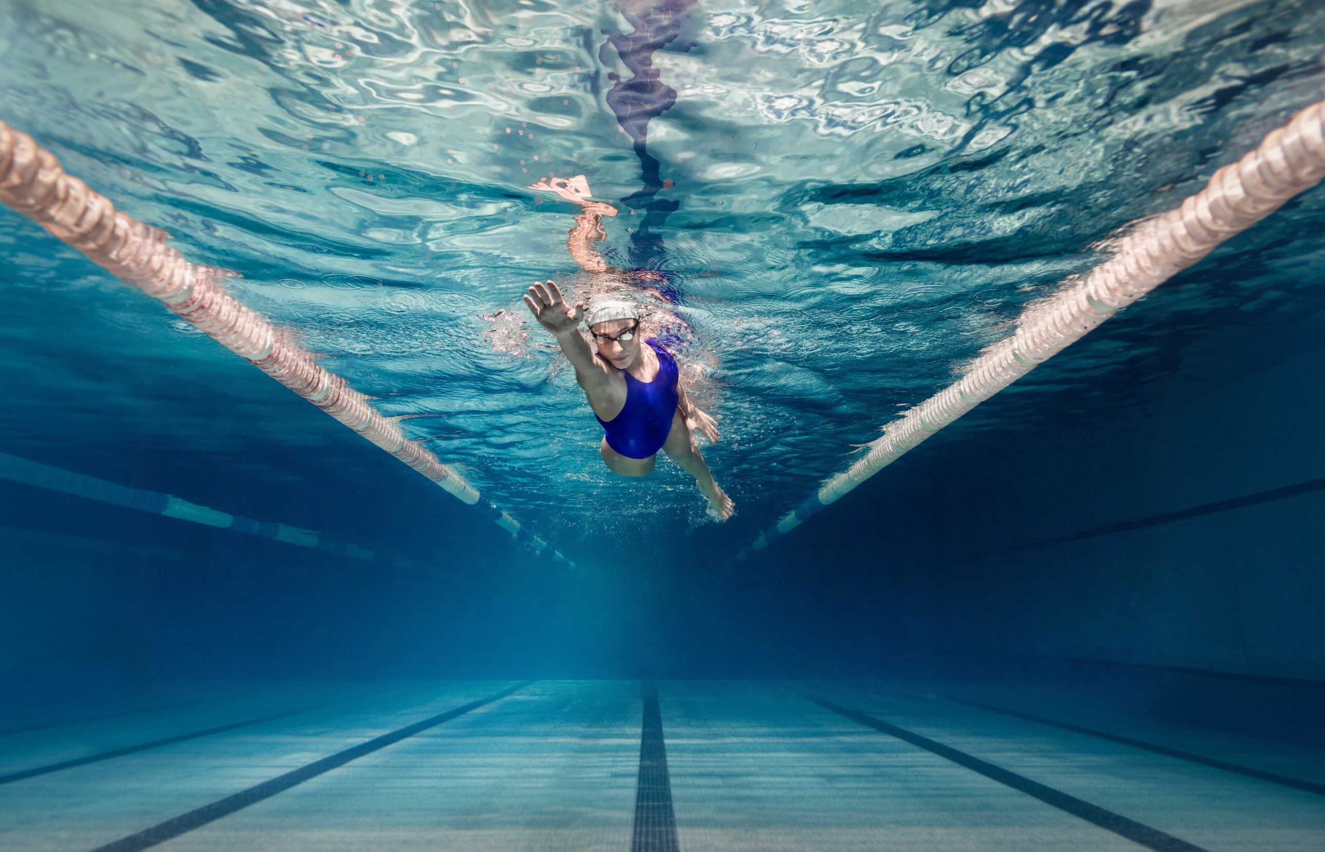 Swimmer training in a commercial lap pool, seen underwater