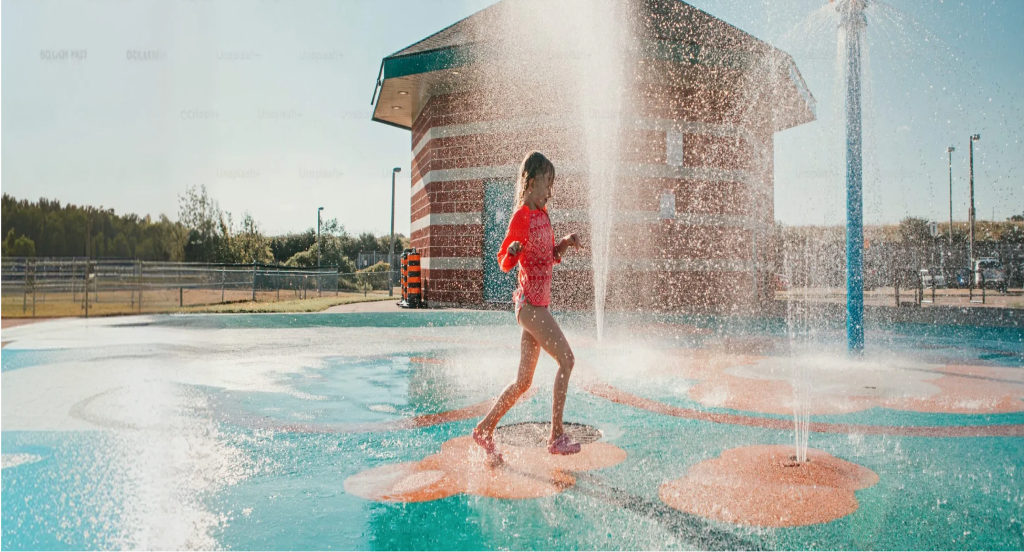 Child running through a splash pad at an aquatic centre