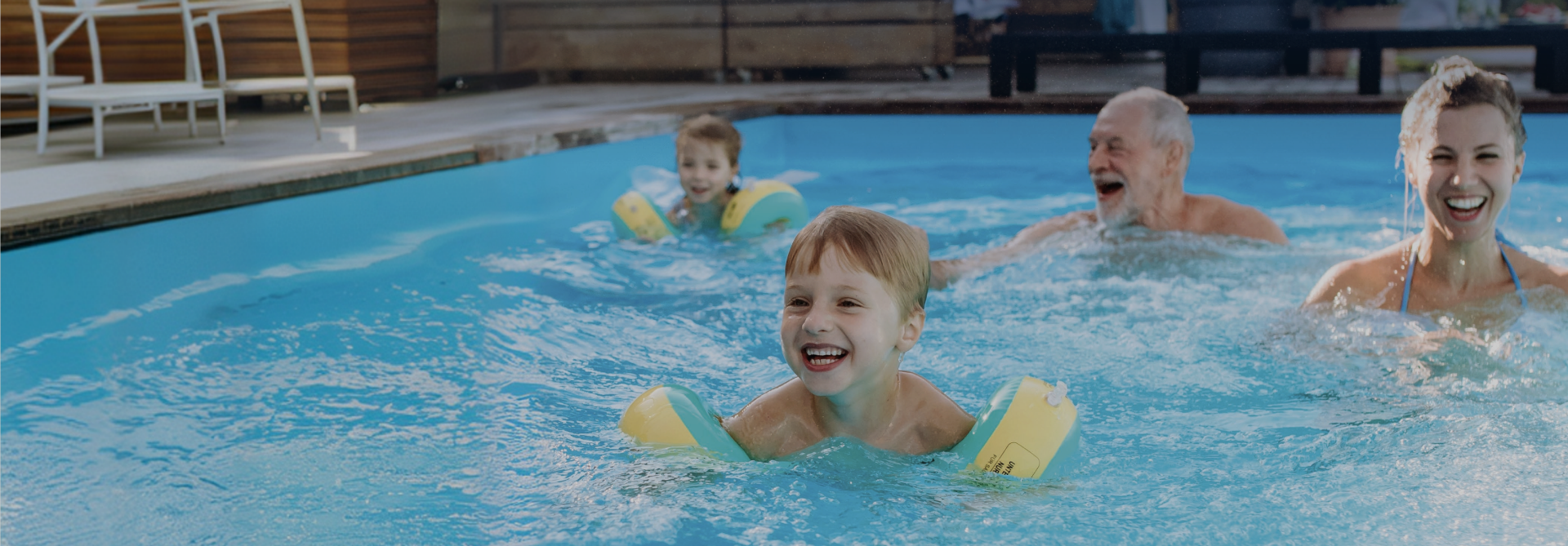 Family playing together in a heated backyard pool