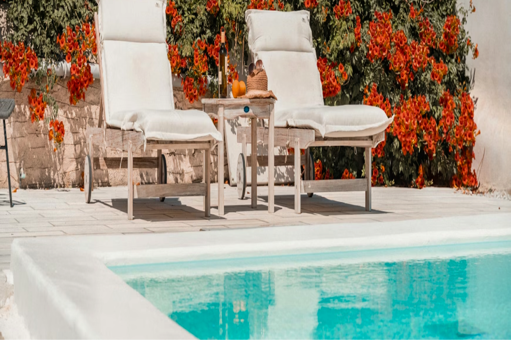 Sun loungers on a timber deck beside a backyard swimming pool
